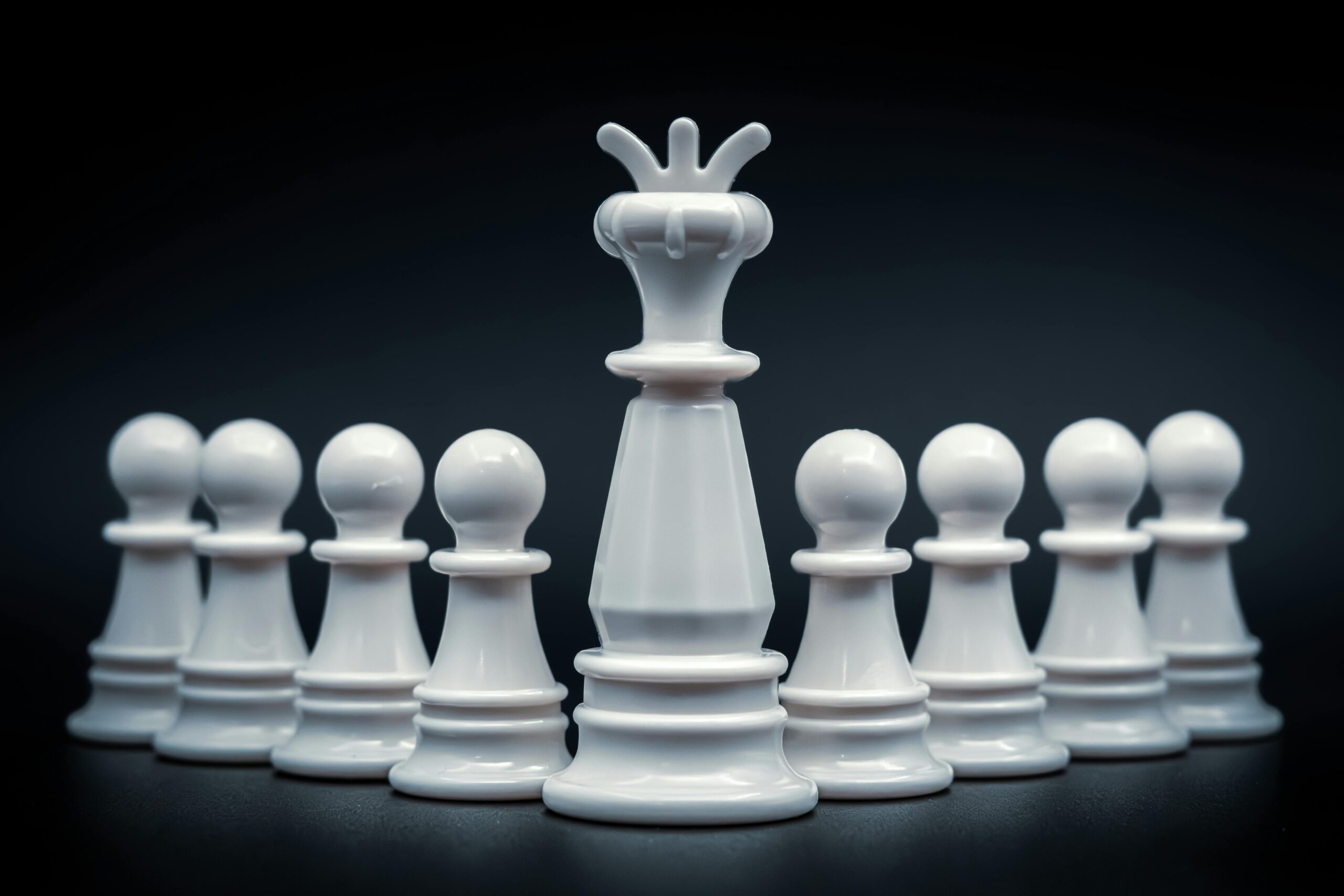 Close-up of white king and pawns on chessboard, symbolizing leadership and strategy.